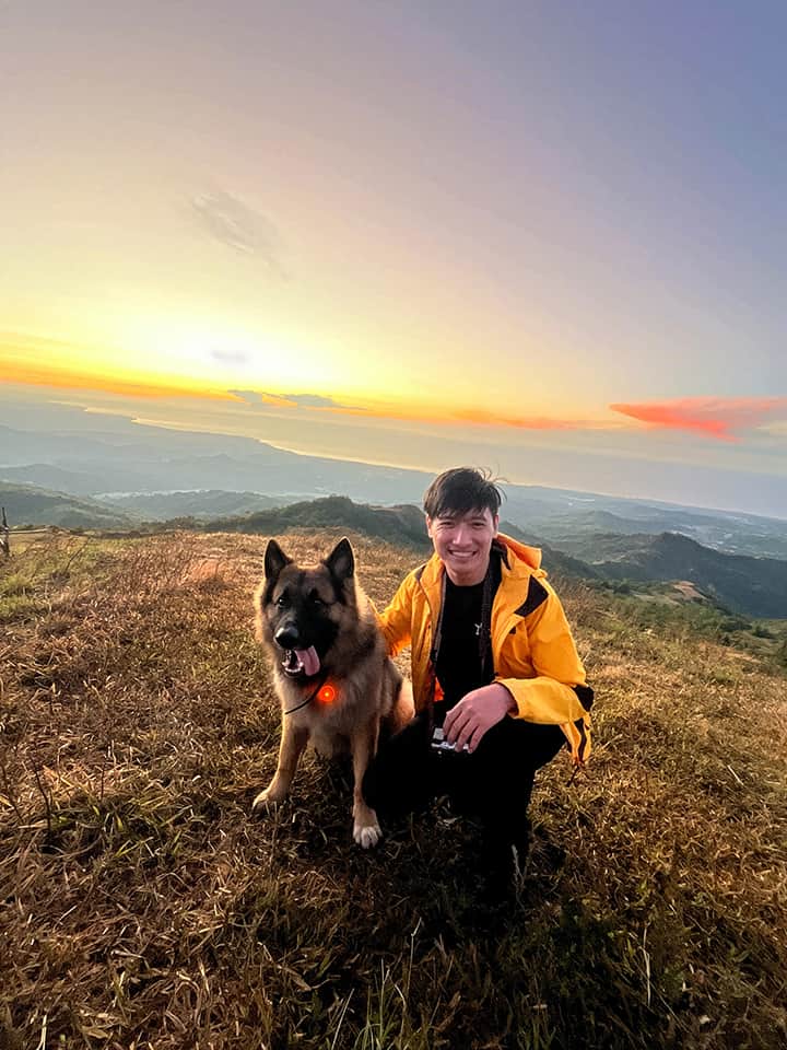 Carl with his dog on a mountain at sunrise, symbolizing stewardship and resilience